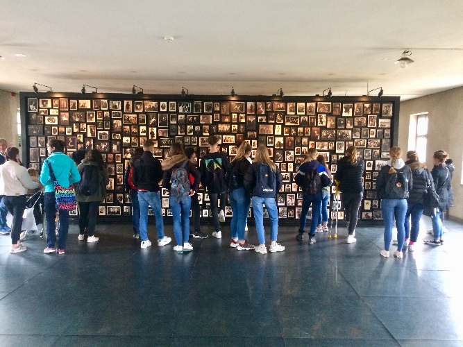 Schülerinnen und Schüler des Gymnasiums Vohwinkel betrachten eine Wand aus Fotographien, die an die Schrecken der NS-Zeit erinnern